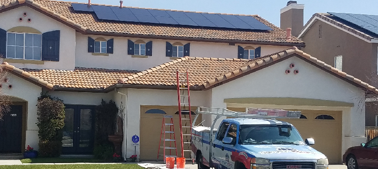 Nineteen solar panels on a two story home with a Semper Solaris truck and ladders.